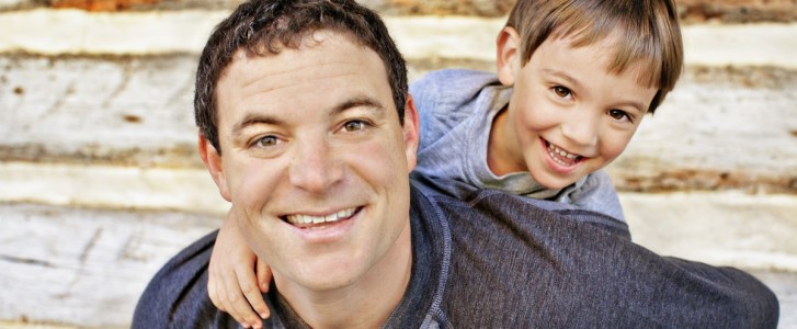 Father giving piggy-back ride to young son