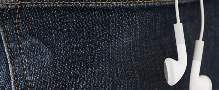 ear buds hanging out of jeans back pocket