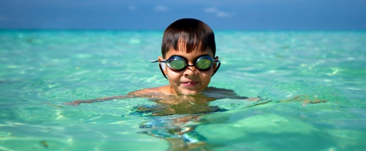 young boy swimming in ocean