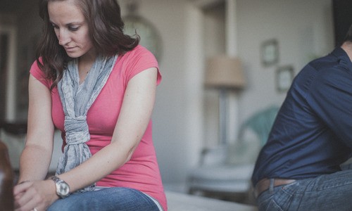 Couple sitting with backs towards each other