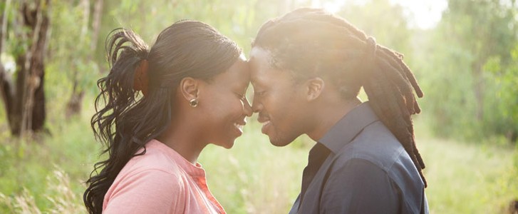 Married couple standing forehead to forehead and smiling