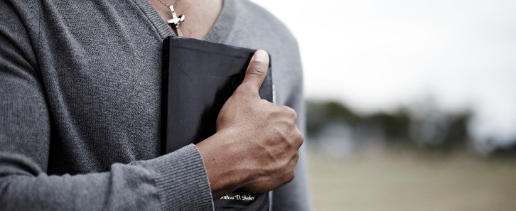 A man holds a Bible to his chest
