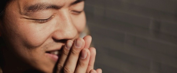 man praying and smiling