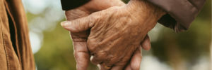 Elderly couple holding hands