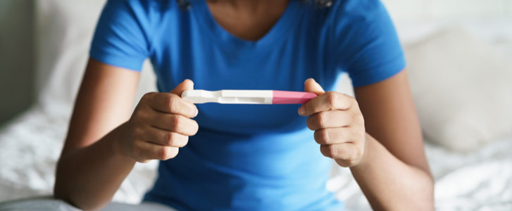 Teenage mom holding a pregnancy test