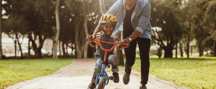 Father helping son ride a bike