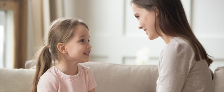 Mother and daughter sitting on a couch