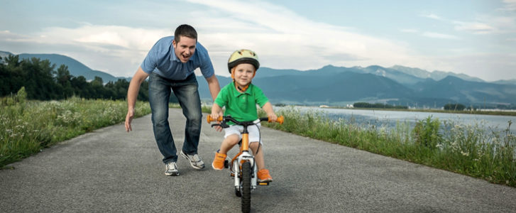 A father teaching his child to ride a bike